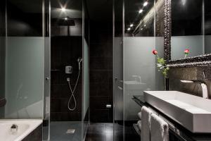 a bathroom with a shower and a sink and a tub at Hotel Bagués, a Small Luxury Hotel of the World in Barcelona