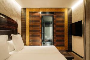 a bedroom with a bed and a television in a room at Hotel Bagués, a Small Luxury Hotel of the World in Barcelona