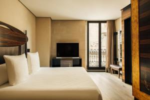 a hotel room with a bed and a television at Hotel Bagués, a Small Luxury Hotel of the World in Barcelona