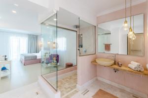 a bathroom with a glass shower and a sink at Malia Mare Hotel in Malia
