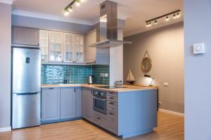 a kitchen with white cabinets and a stainless steel refrigerator at Apartament Villa Nautica in Rydzewo