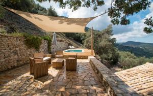 a backyard with a pool and a patio with a umbrella at Castelli Olive Press in Acharavi