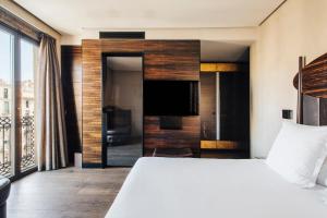 a bedroom with a large bed and a tv at Hotel Bagués, a Small Luxury Hotel of the World in Barcelona