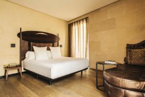 a hotel room with a bed and a couch at Hotel Bagués, a Small Luxury Hotel of the World in Barcelona