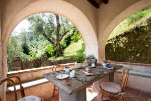 a stone table and chairs in a room with a window at Villa Doriana in Camaiore