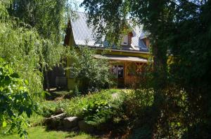 Blick auf ein Haus aus dem Garten in der Unterkunft Agrowczasy u Mirusi in Wiżajny