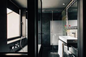 a bathroom with a shower and a sink and a mirror at Hotel Bagués, a Small Luxury Hotel of the World in Barcelona