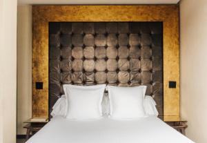 a bedroom with a large bed with white pillows at Hotel Bagués, a Small Luxury Hotel of the World in Barcelona