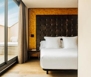 a bedroom with a large bed and a window at Hotel Bagués, a Small Luxury Hotel of the World in Barcelona