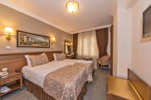 Un pat sau paturi într-o cameră la Laleli Gonen Hotel