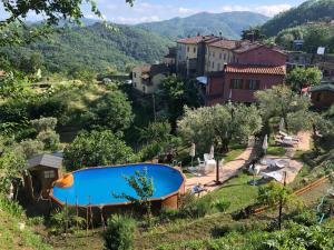 a small village with a blue swimming pool in a hill at B&B Puccini in Pescaglia