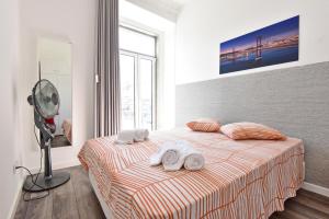a bedroom with a bed with two towels on it at TryLisbon Calvário in Lisbon