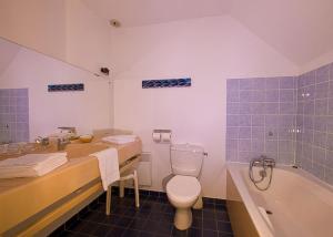 La salle de bains est pourvue de toilettes, d'un lavabo et d'une baignoire. dans l'établissement Hotel le Crouesty, à Arzon