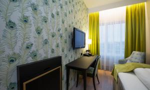 a bedroom with a desk and a tv on a wall at Thon Hotel Opera in Oslo