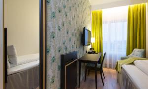a hotel room with a desk and a bedroom at Thon Hotel Opera in Oslo