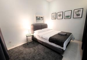 a bedroom with a bed and a table and pictures on the wall at Fivehouz Guest House in Petaling Jaya