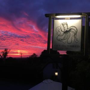 a sign for a pub with a sunset in the background at The Hundred of Ashendon in Waddesdon