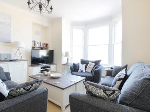sala de estar con 2 sofás y TV en Seashore House, en Newquay