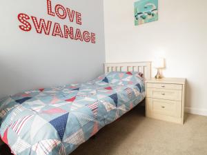 a bedroom with a bed and a sign that reads love variance at Swanage Bay Apartment in Swanage