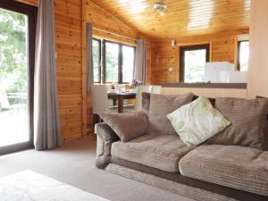 ein Wohnzimmer mit einem Sofa und einem Tisch in der Unterkunft Oak Lodge in Falmouth