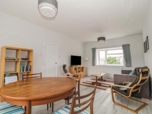 a living room with a wooden table and chairs at Swanage Bay Apartment in Swanage
