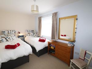a bedroom with two beds and a mirror and a chair at Starfield in Lincoln
