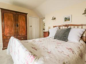 a bedroom with a large bed with a wooden headboard at Lilac Cottage in Great Malvern