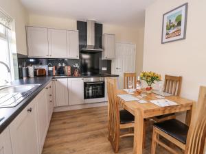 a kitchen with a wooden table and a dining room at Tegfan in Rhayader