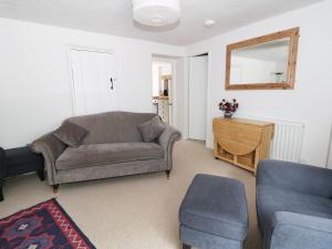 a living room with a couch and a mirror at Gritstone Cottage in Bakewell