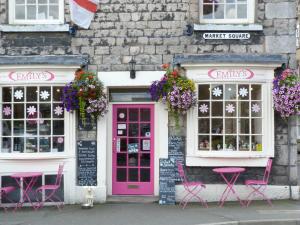 una porta rosa e delle sedie davanti a un edificio di Courtyard Cottage a Kirkby Lonsdale
