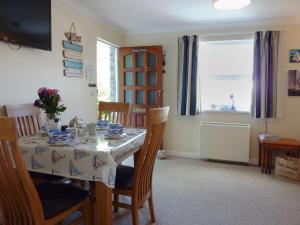 a dining room with a table and chairs and a window at Stones Throw in Saint Mawes