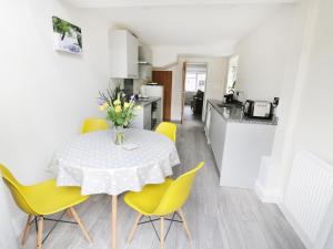 a kitchen and dining room with a table and yellow chairs at 25 Shakespeare Street in Stratford-upon-Avon