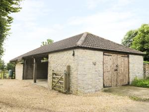 an old brick building with a wooden door at The Old Goat Barn at Trout Cottage in Somerton