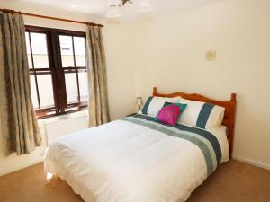 a bedroom with a bed and a window at 5 Chandlers Yard in Burry Port