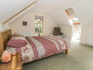 a bedroom with a large bed in a attic at Squirrels Drey in Little Dunham