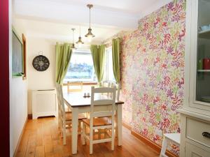 a dining room with a table and a pink floral wall at Westhaven in Mallaig