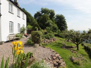 a garden in front of a white house at Lilac Cottage in Great Malvern