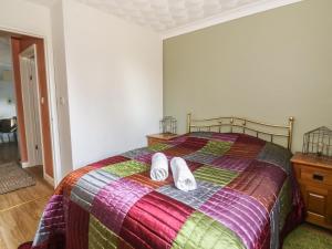 a bedroom with a bed with two white towels on it at Little Beck Cottage in Harleston