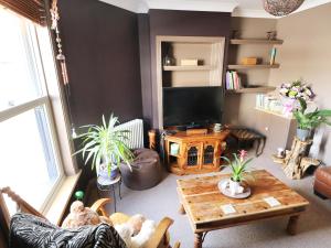 a living room with a tv and a table at Rose Cottage in Great Yarmouth