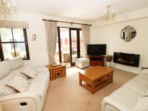 a living room with white furniture and a flat screen tv at 5 Chandlers Yard in Burry Port