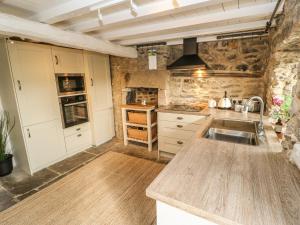 a kitchen with a sink and a counter top at Box Tree Cottage in Buxton