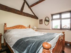 een slaapkamer met een groot bed met een houten frame bij The Courtyard in Kington