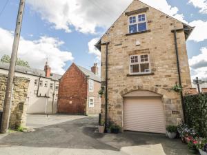 an old brick house with a garage at River Cottage in Morpeth