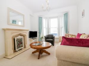 sala de estar con sofá y chimenea en Panoramic Cottage en Brixham