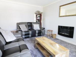 a living room with two leather couches and a tv at Seaspray in Withernsea
