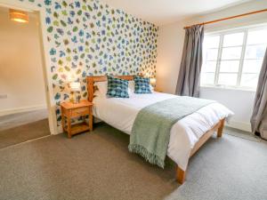 1 dormitorio con cama y ventana en The Armourers Forge en Ashburton