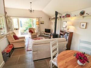 a living room with a couch and a table at Henhouse Cottage in Gillamoor