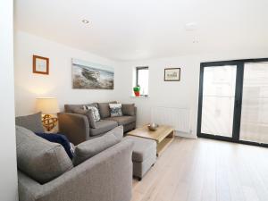 a living room with two couches and a table at 7 Ocean Gateway in Hythe