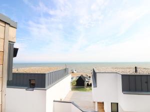 a view of the beach from the balcony of a beach house at 7 Ocean Gateway in Hythe
