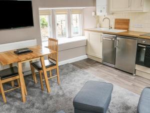 a small kitchen with a wooden table and a dining room at The Little Flat in Barnard Castle